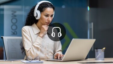 A woman with headphones looking at a laptop computer