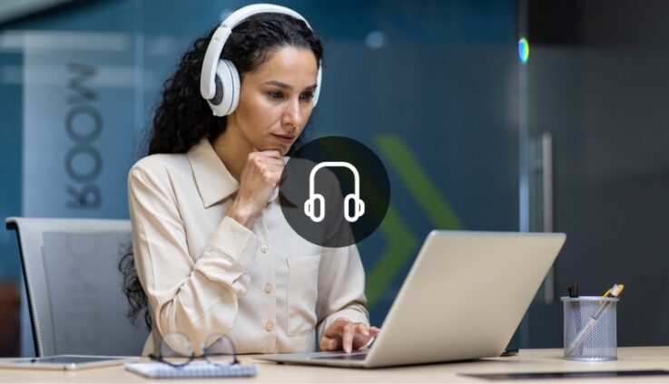 A woman with headphones looking at a laptop computer