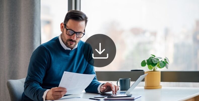 A man with glasses sitting in desk and reviewing a document