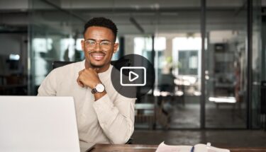 Man sitting on desk smiling