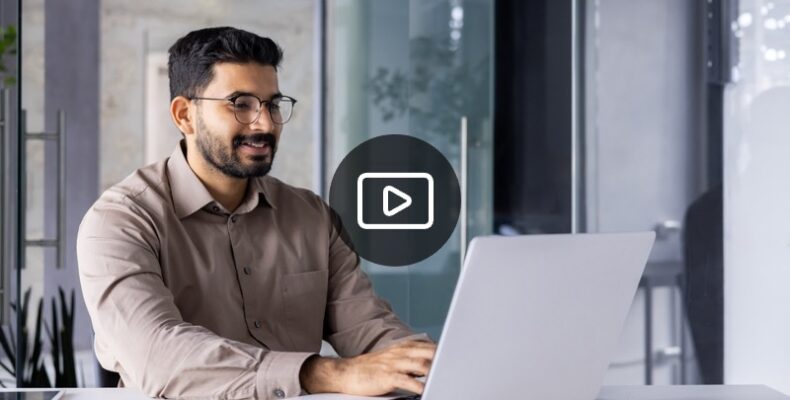 Man with glasses typing on computer