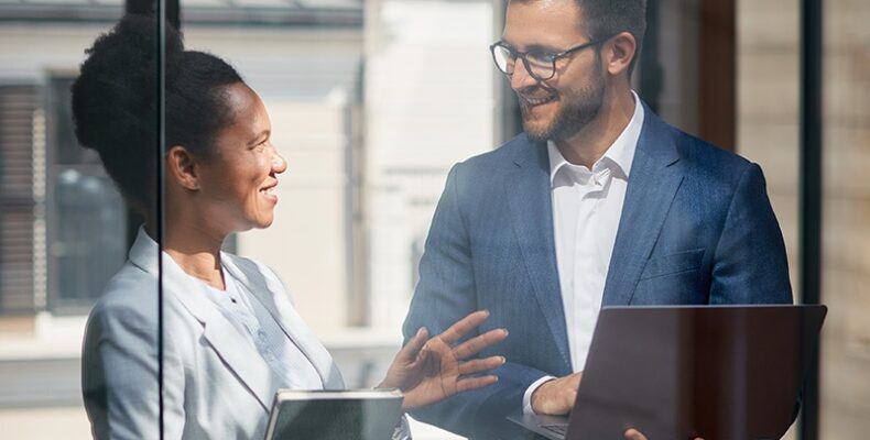Man and woman speaking while reviewing something on the computer