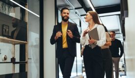 A man and a woman walking in an office setting