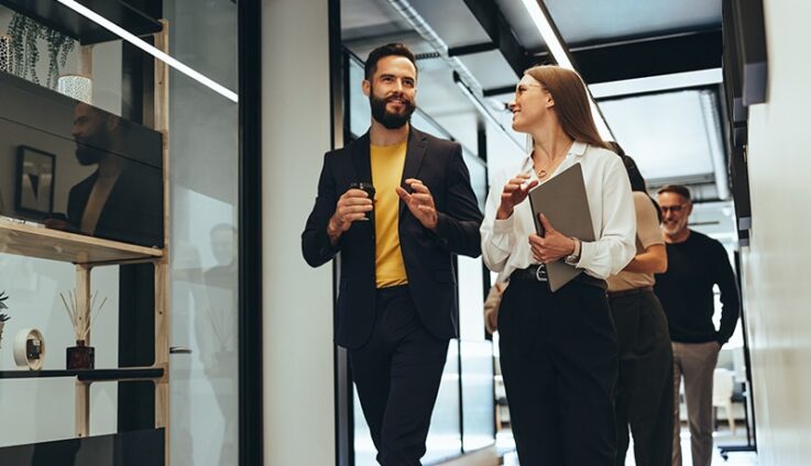 A man and a woman walking in an office setting