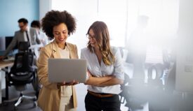 Two women in office looking at laptop