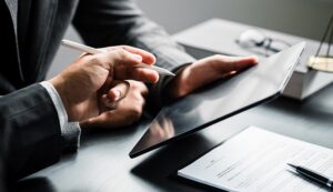 Two people pointing at a tablet