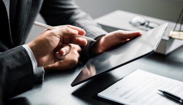 Two people pointing at a tablet