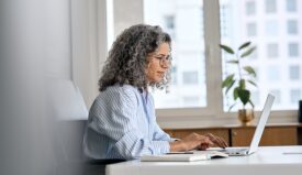 Woman typing into a laptop computer
