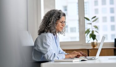Woman typing into a laptop computer