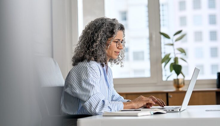 Woman typing into a laptop computer