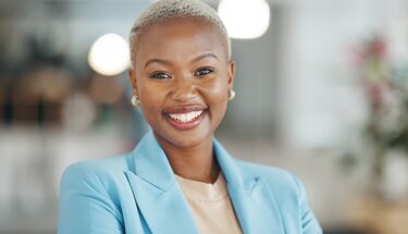 A brightly lit image of professional standing in a modern office setting.