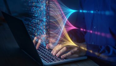 A person typing in a laptop computer
