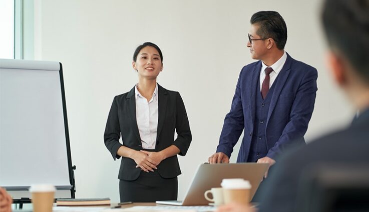 Professionally dressed woman giving a presentation in office setting