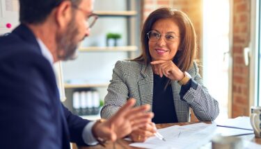 A woman and man speaking with each other in an office setting