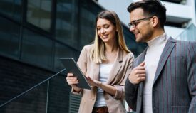 Professionally dressed man and woman looking at a tablet